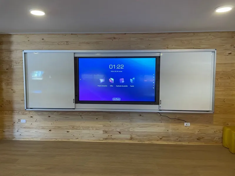 Pizarra GuardCase abierta en una sala con muro de madera, con la pantalla interactiva encendida al centro