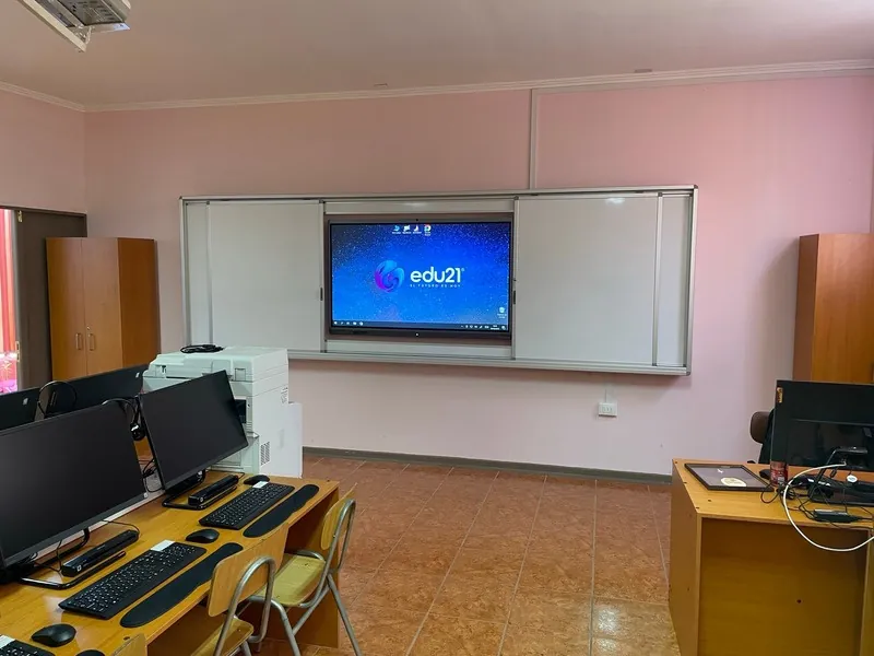 Pizarra GuardCase en una sala de computación de muros rosados, con la pantalla interactiva visible