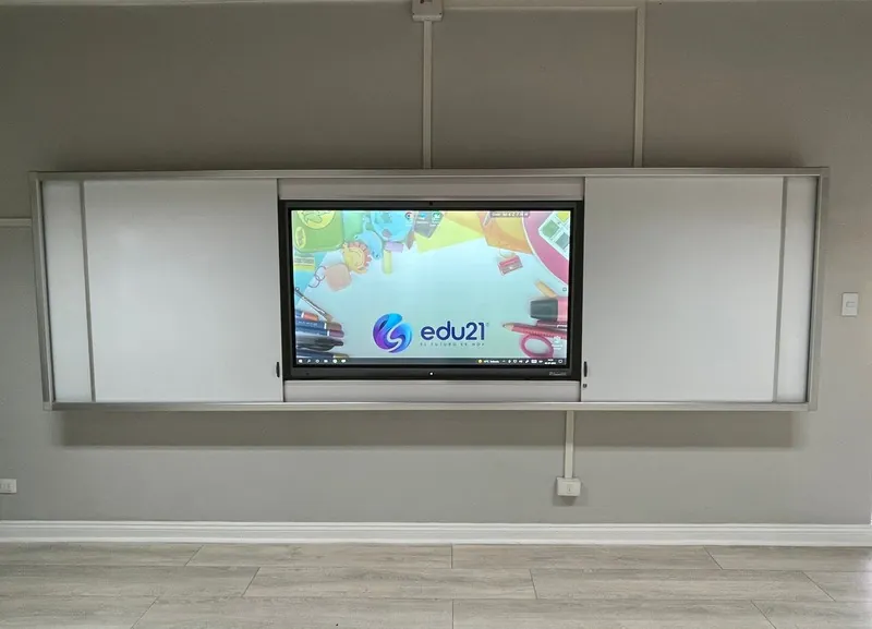Pizarra GuardCase instalada en una sala de muros grises, con la pantalla interactiva al centro