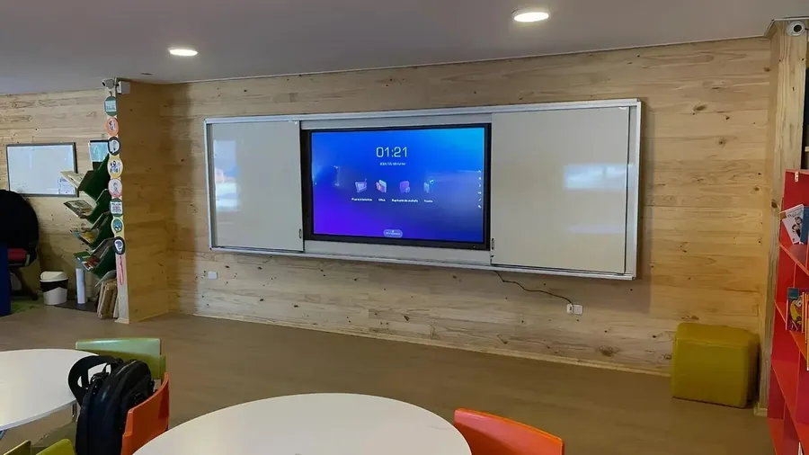 Pantalla interactiva EDU21 instalada en una sala, con su pizarra protectora deslizante